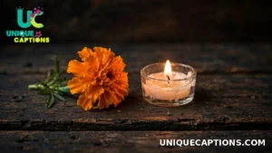 One marigold flower and one small candle resting on dark wood for a simple Day of the Dead tribute
