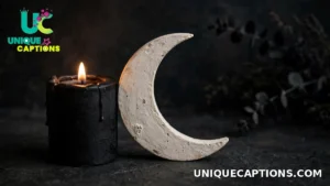 Single black candle beside a small crescent moon prop